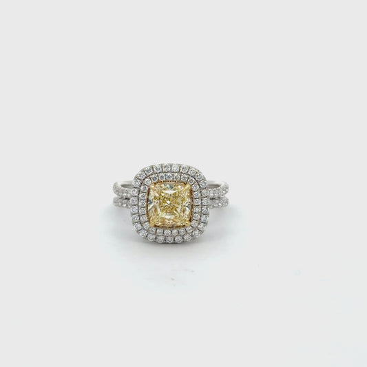 Double Halo Ring in 14kt. White Gold with 2 carat Natural Mined GIA Fancy Light Yellow Cushion with Round Diamonds on the band.