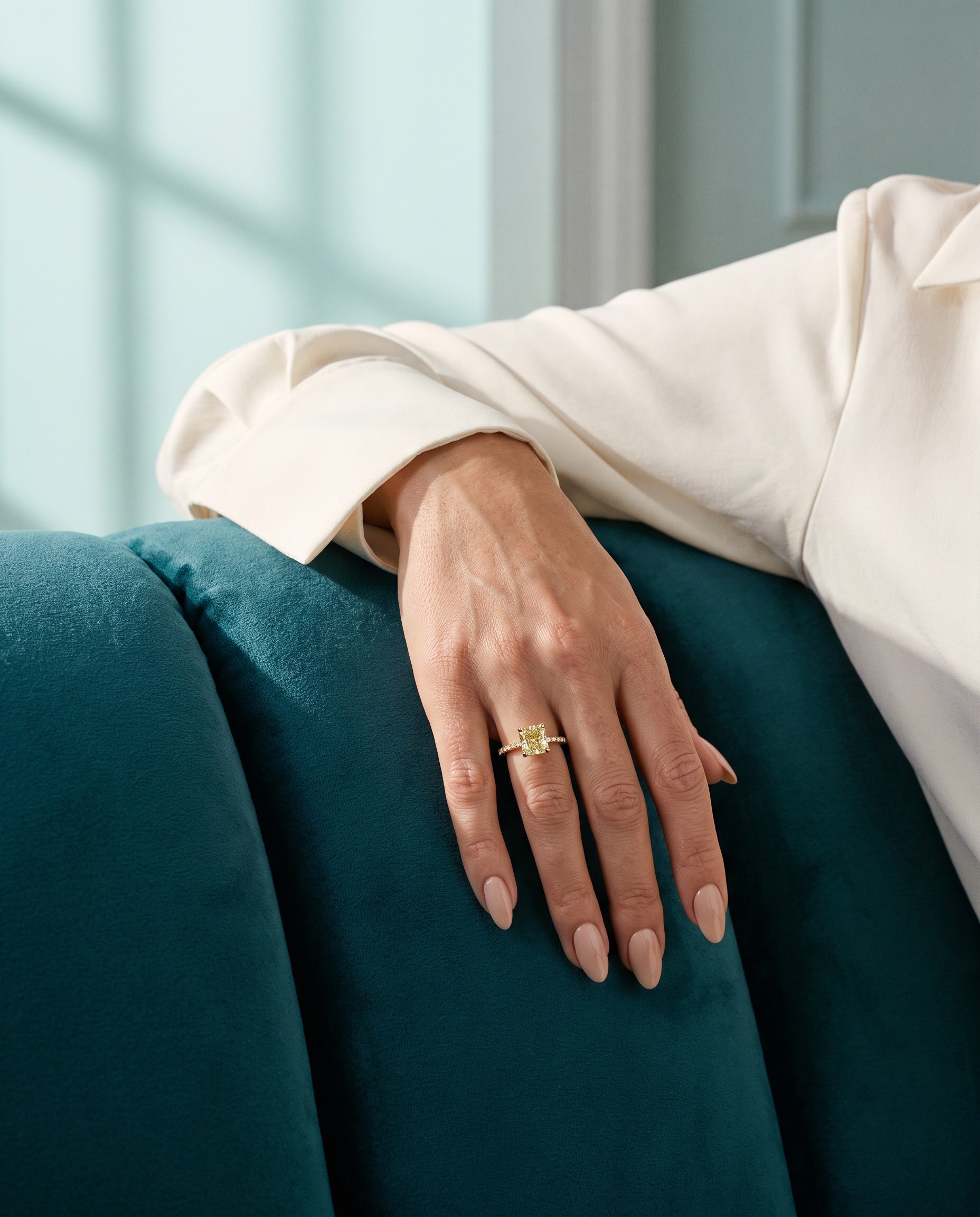 A distinctive ring worn on a hand resting on teal velvet