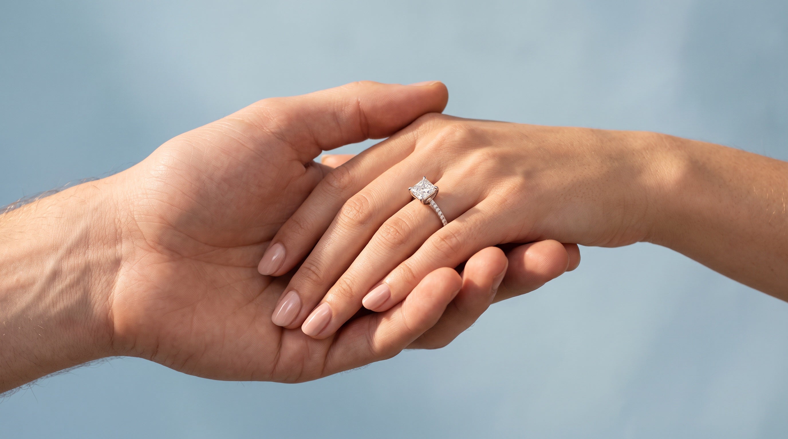 A diamond ring on a hand held by a partner